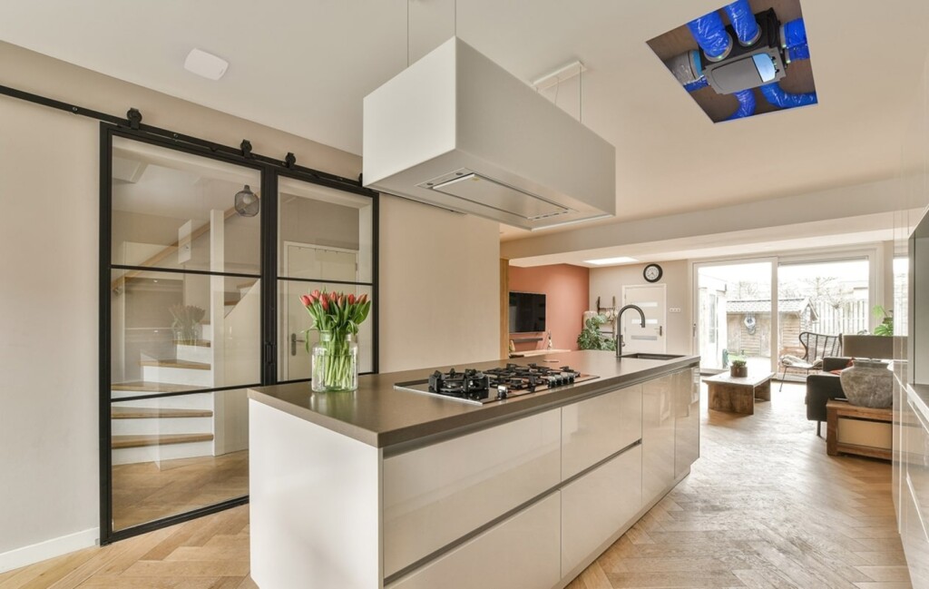 Installation de VMC dans une maison moderne du Var, montrant les conduits de ventilation intégrés au plafond d'une cuisine ouverte lumineuse.