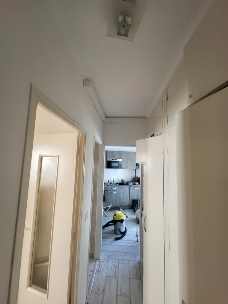 Goulottes blanches dissimulant les liaisons de climatisation dans le couloir d’un appartement à Toulon