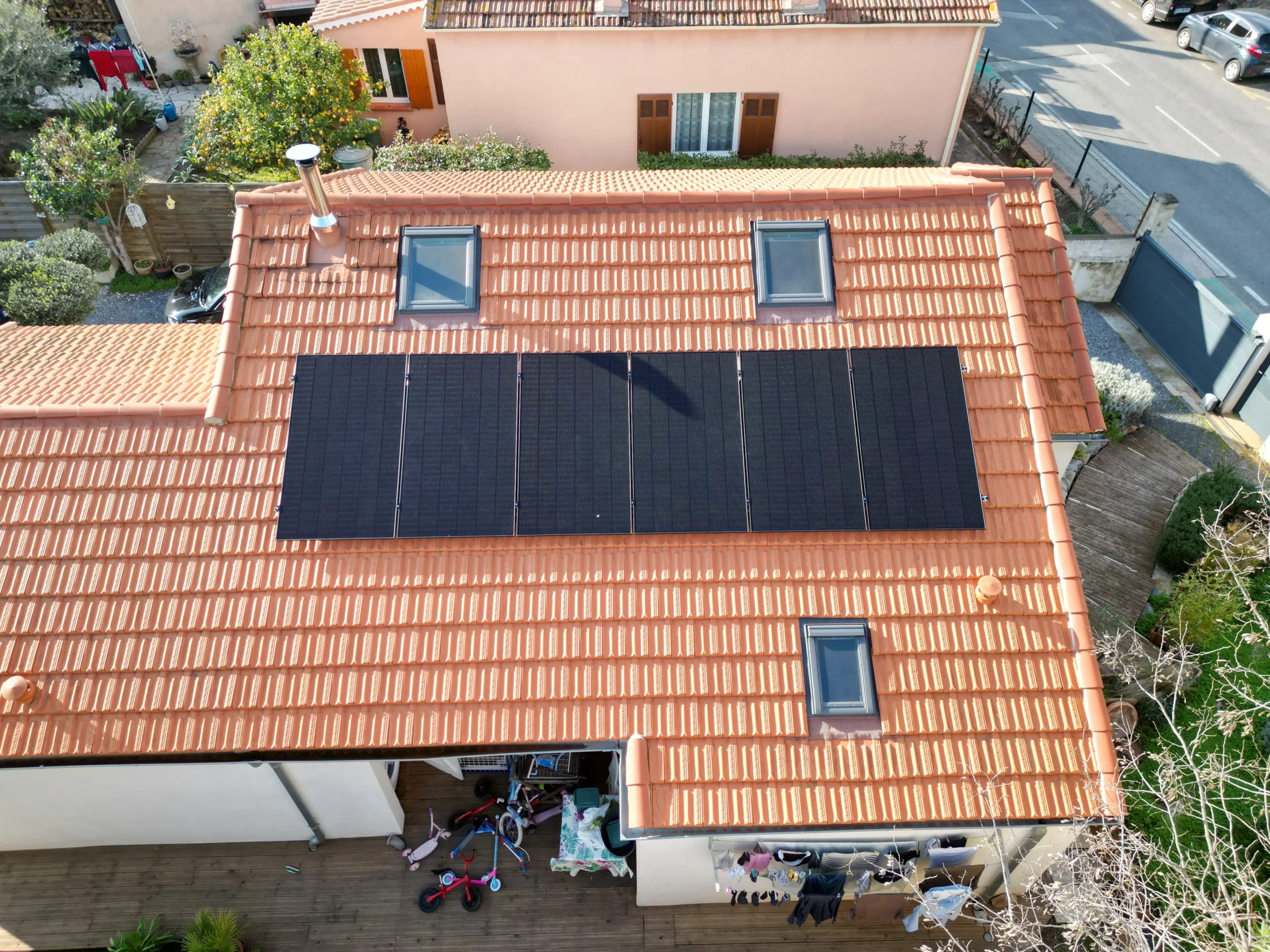 Installation solaire photovoltaïque avec panneaux noirs sur une toiture inclinée en tuiles rouges à Hyères