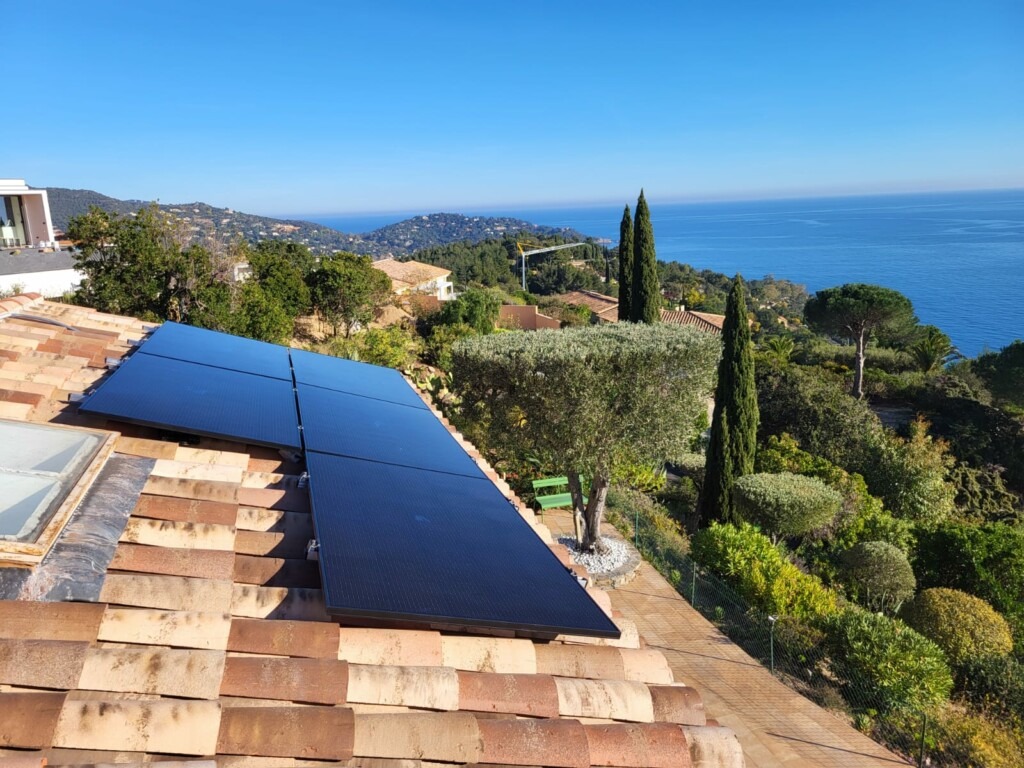 Installation de panneaux solaires photovoltaïques avec micros onduleurs en toiture sur une maison individuelle avec vue mer