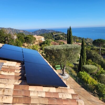 Installation de panneaux solaires photovoltaïques avec micros onduleurs en toiture sur une maison individuelle avec vue mer