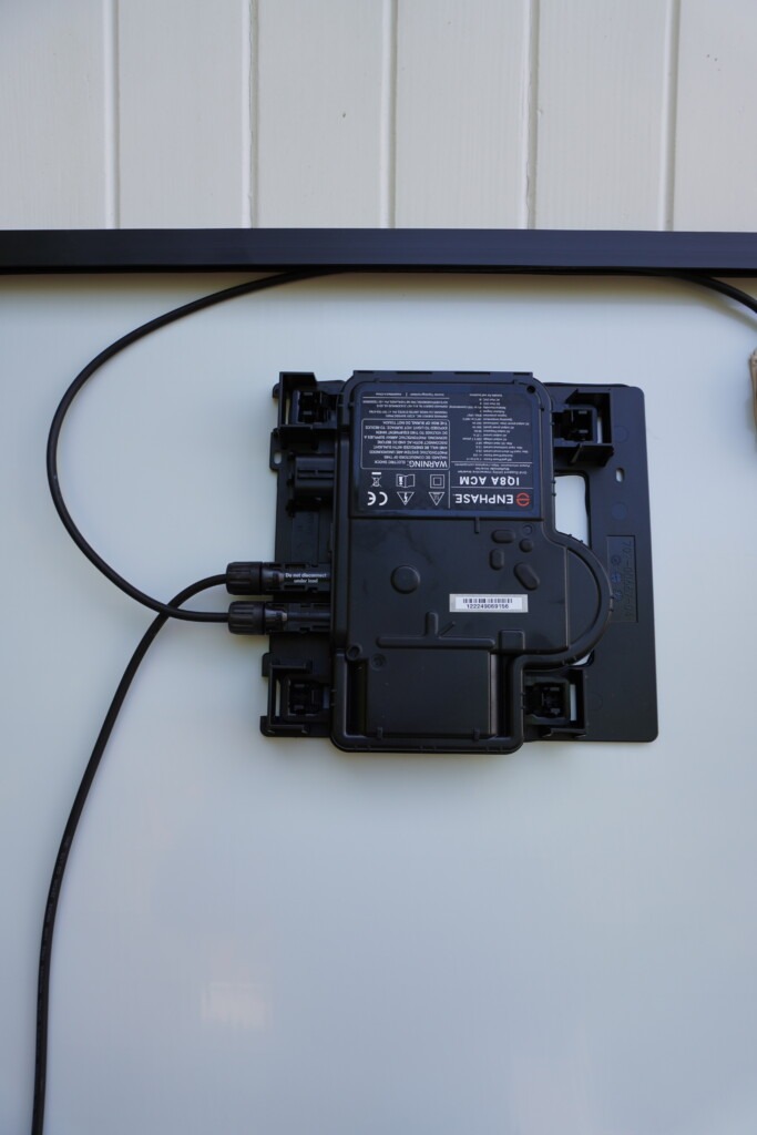 Micro-onduleur Enphase installé sous un panneau solaire pour une production indépendante par module