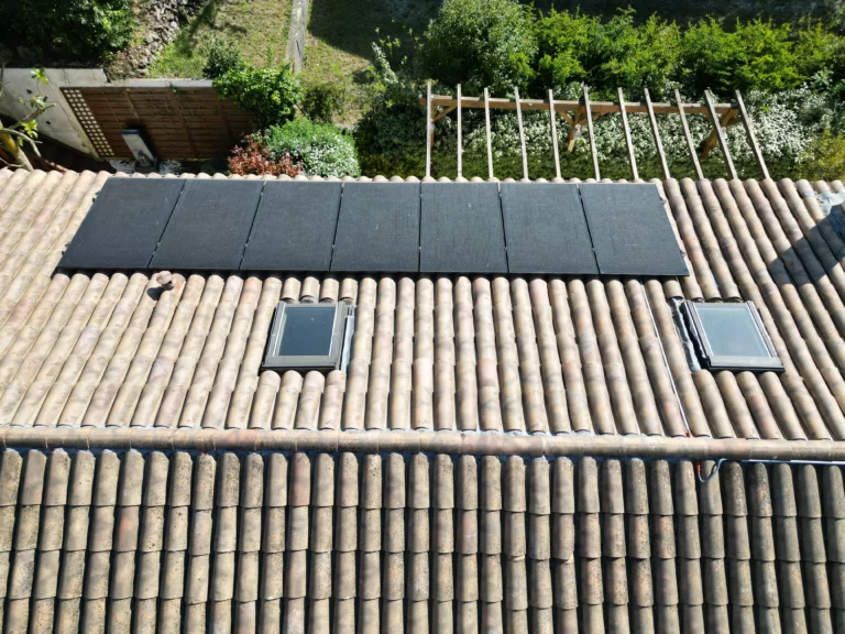 Vue rapprochée des panneaux solaires et fenêtres de toit sur une maison à Toulon